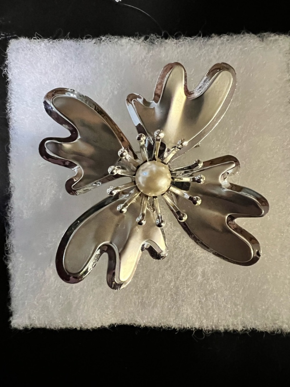 Vintage silver tone stylized flower with faux pearl center accent.